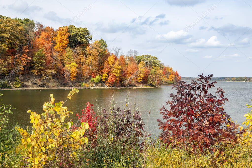 Colorful autumn foliage surrounds the shores of Eagle Creek Reservoir in Indianapolis, Indiana.