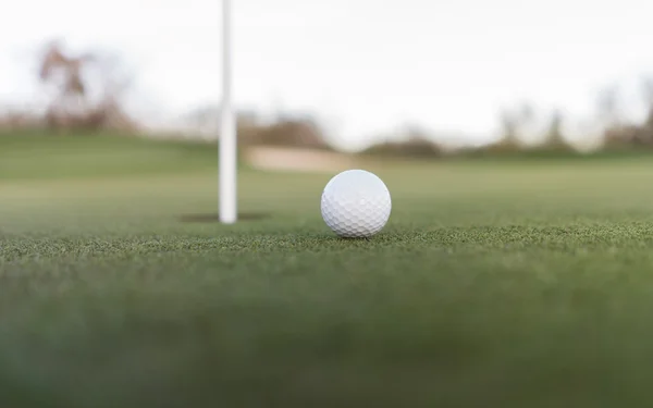 Goldball in der Nähe des Becherlochs auf dem Putting Green — Stockfoto