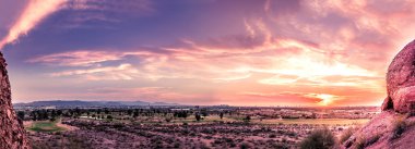 Geç akşam kırmızı gökyüzü Phoenix, Arizona üzerinden günbatımı Panoraması. Papago Parkı buttes ön planda.