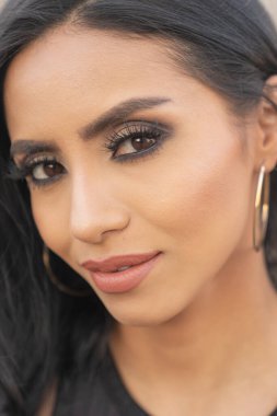 Muhteşem gözleri ve uzun siyah saçları olan güzel bir kadın.