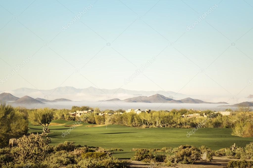 Golf course with dramatic unusual low lying fog in distant Pheonix,Az,USA
