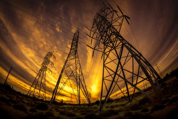 Macht elektriciteitsmasten bij zonsondergang — Stockfoto