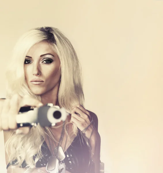 Piękna blond młoda kobieta trzyma pistolet — Zdjęcie stockowe