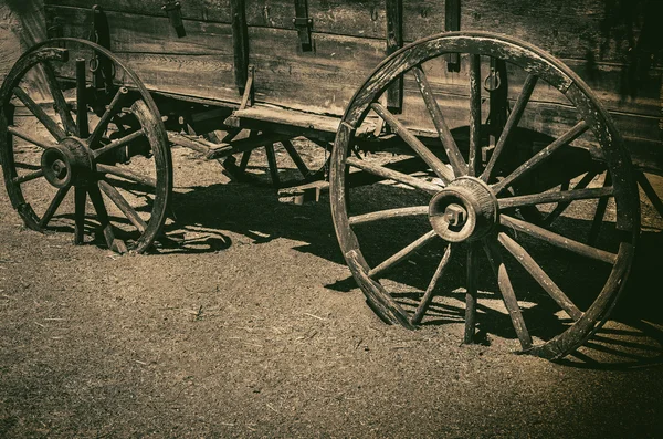 Szimbolikus fogalom amerikai vadnyugati Cowboy a régi kocsi kerék. — Stock Fotó