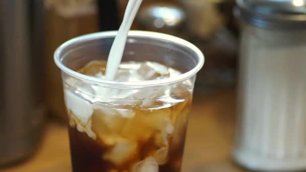 Vidéo de café glacé servi avec de la crème, puis remué 