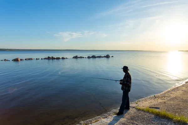 Pêcheur sur une rivière au coucher du soleil — Photo