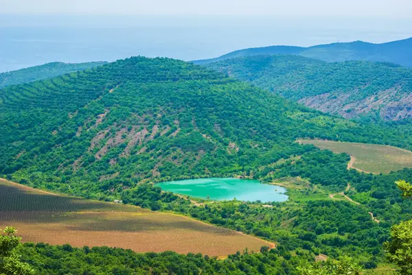 Wunderschöner smaragdgrüner See inmitten grüner Berge — Stockfoto