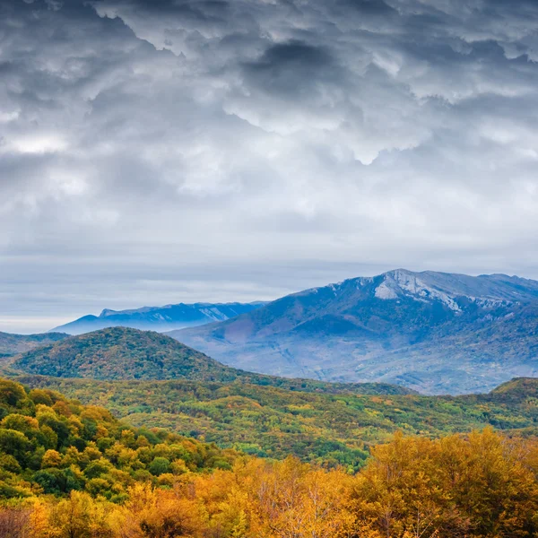 Montañas brumosas de otoño bajo densas nubes —  Fotos de Stock