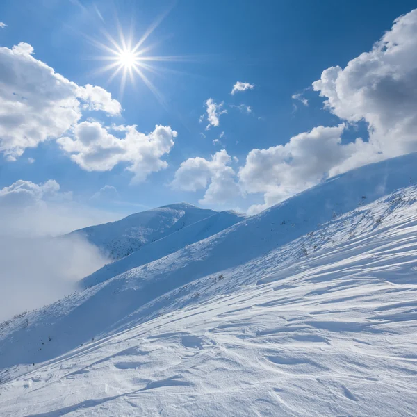 Inverno montanha nevada sob um sol cintilante — Fotografia de Stock