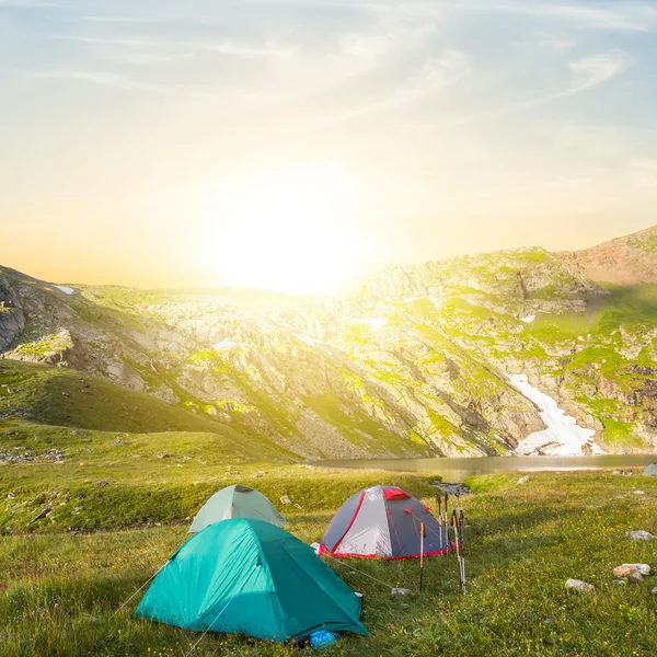 Acampamento turístico em um vale de montanha verde ao pôr do sol — Fotografia de Stock