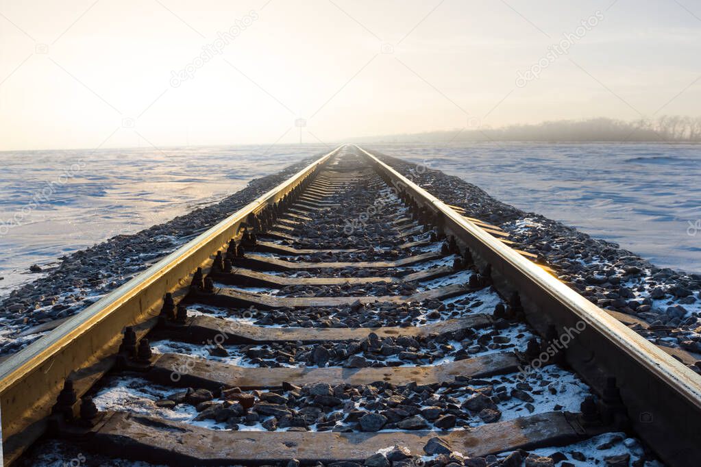 closeup railway among snowbound plain at the sunrise