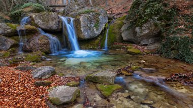 small waterfall on autumn mountain river