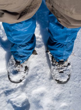 closeup human traveler legs stay on a snow, winter travel background
