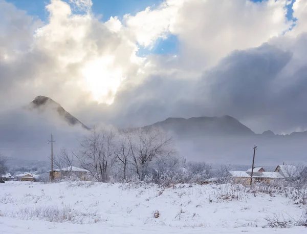 小村庄在雪地里靠近山链 冬季乡村景色 — 图库照片