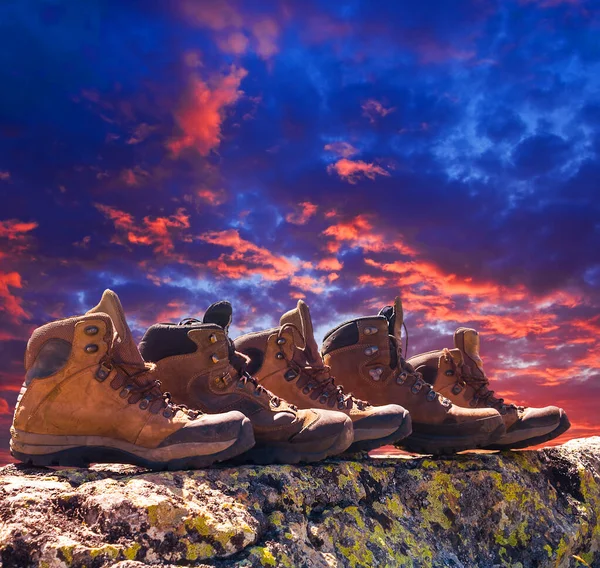 在一个戏剧性的日落背景下 特写旅游靴留在石头上 — 图库照片