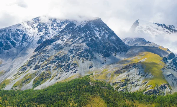 在雪地和浓密的云彩中的特写山 — 图库照片