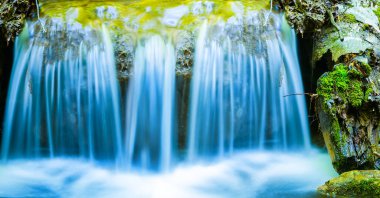 Dağ nehrindeki şelaleye yakın, güzel doğal bir arka plan.