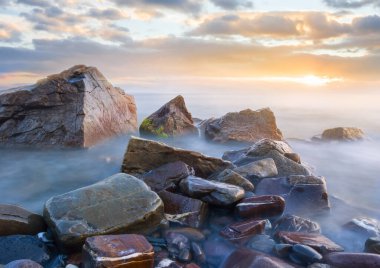 Alacakaranlıkta taşları olan sakin deniz kıyıları, doğal deniz arka planı