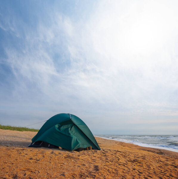 зеленая туристическая палатка пребывания на песчаном бурном морском пляже, летняя поездка фон