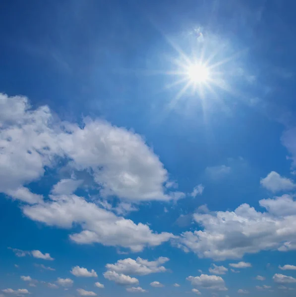 在积云中闪耀的太阳 蓝色的夏日天空背景 — 图库照片