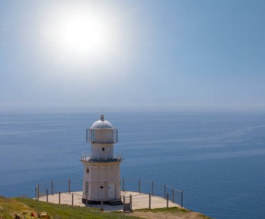 Güneşli yaz gününde deniz fenerinde bir pelerin üzerinde
