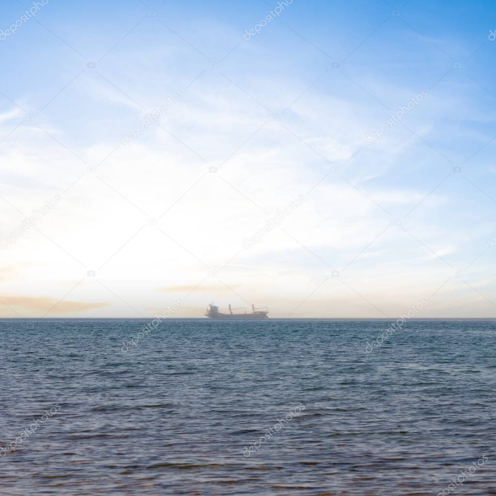 cargo ship in a sea at the sunset, marine transportation scene