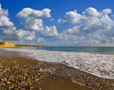 Bulutlu bir gökyüzünün altındaki zümrüt deniz kıyısı, yaz deniz manzarası, tatil geçmişi