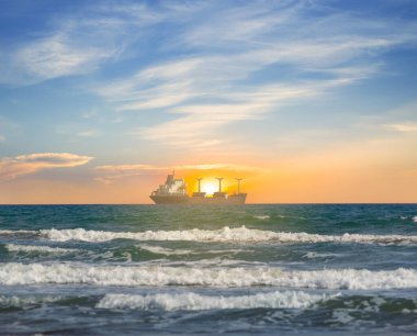 Günbatımında zümrüt denizde kargo gemisi, ulaşım teknolojisi arka planı.