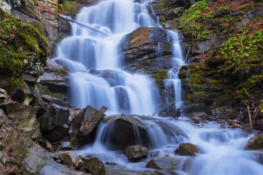 closeup big blue waterfall in mountain canyon