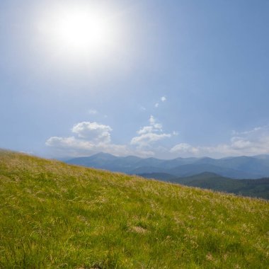 Işıldayan güneşin altındaki yeşil dağ vadisi, yaz yolculuğu sahnesi