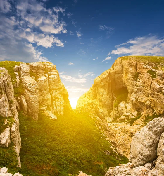 Akşam güneşi dağ sırtındaki çatlaktan geçerek, doğal arka planda seyahat eder.
