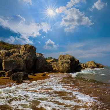 Güneşli yaz gününde taşlı deniz plajı
