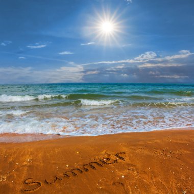 Sıcak yaz güneşli bir günde kumsalda tabelası olan kumlu bir sahil.