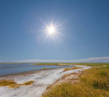 Güneşli bir günde bozkır arasında küçük bir göl