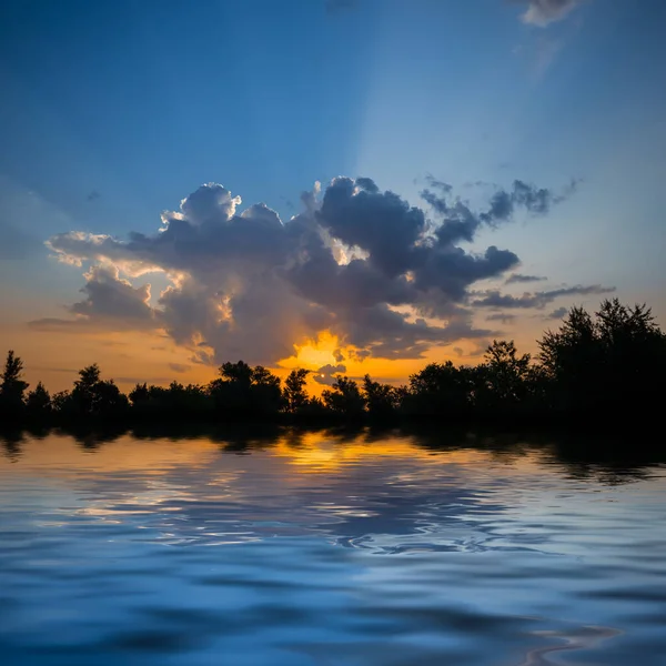 静かな湖や自然の夕景の上の劇的な夕日 — ストック写真