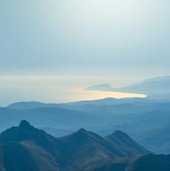 Blauwe mistige bergen en een zee baai — Stockfoto