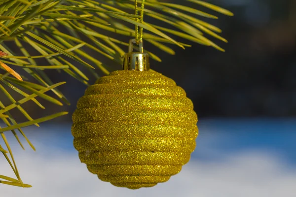 Fechar a bola de ano novo amarelo em um pinheiro — Fotografia de Stock