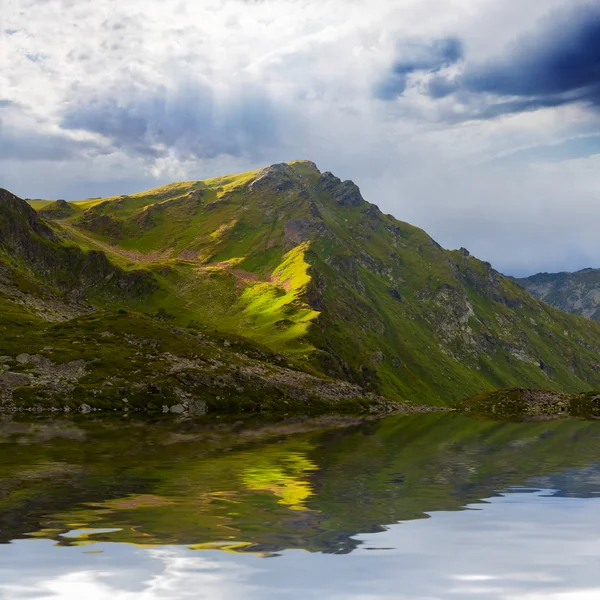 Yeşil dağ bir suya yansıyan