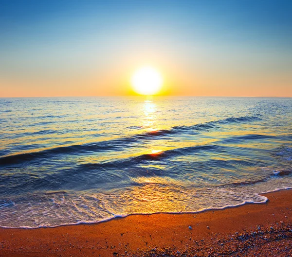 Tramonto su una tranquilla spiaggia sul mare — Foto Stock