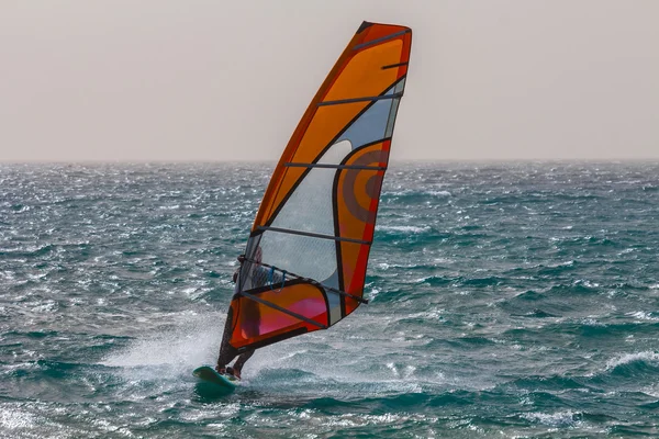 Windsurfer rijden over een golven — Stockfoto