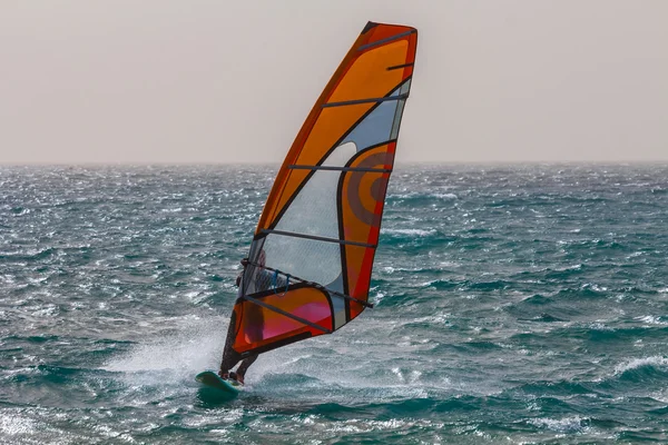 Windsurfer riding over a waves Stock Picture