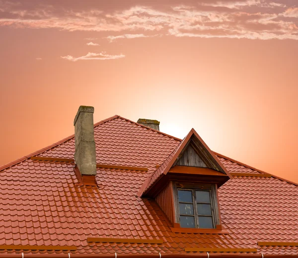 Velho telhado da casa europeia em um fundo por do sol — Fotografia de Stock