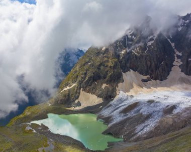 Karlı dağ sırtı sisli ve yoğun bulutlu, dağ yolculuğu sahnesi