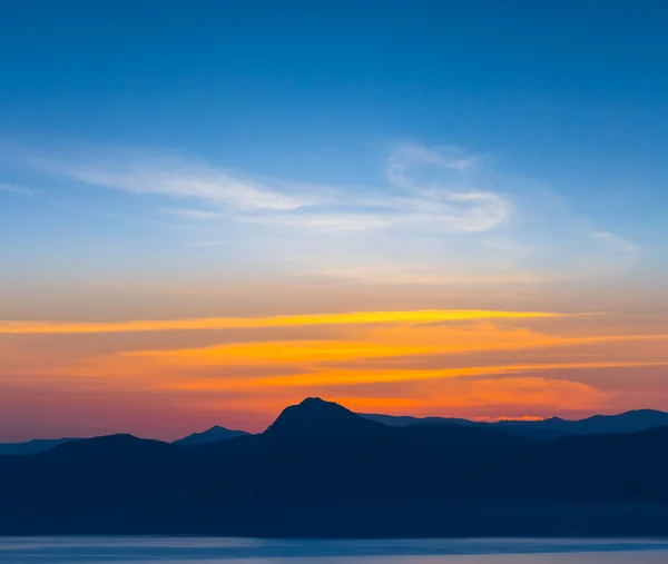 Zonsondergang op een achtergrond van heuvels — Stockfoto