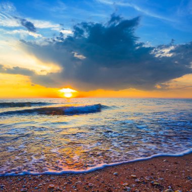 Geniş kumlu sahil dramatik günbatımı, yaz tatili sahnesi