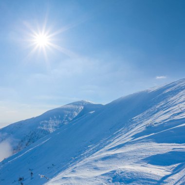 Soğuk güneşli kış gününde, kar altında dağ sırtı mevsimsel seyahat sahnesi