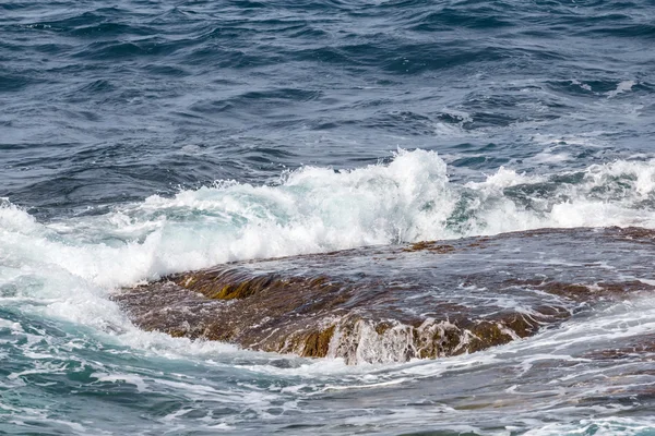 Nahaufnahme Meer vawes über einem Stein — Stockfoto