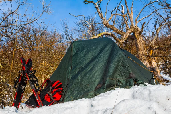 Acampamento turístico em uma encosta de montanha com neve — Fotografia de Stock