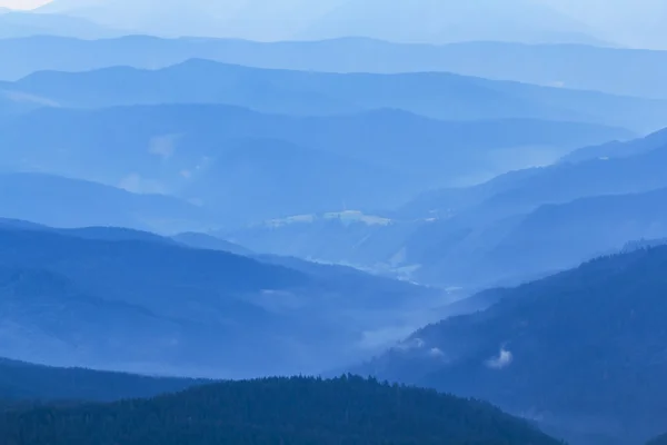 Blu nebbiosa valle di montagna al mattino — Foto Stock