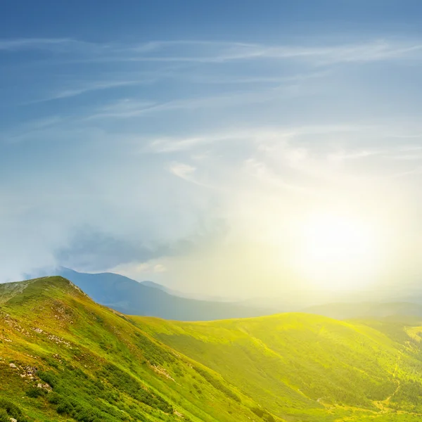 Schöner Sonnenaufgang über einem grünen Bergrücken — Stockfoto
